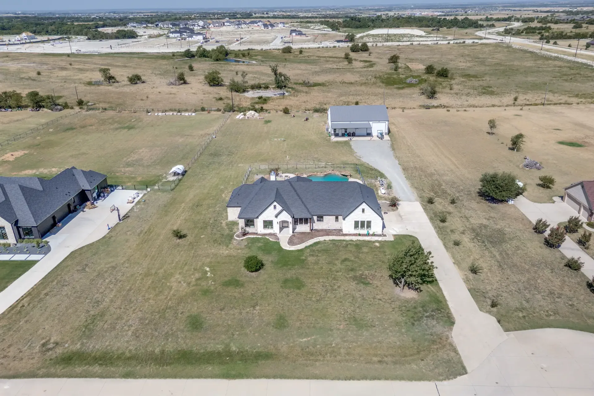 Aerial view showing the house, pool, patio, and the workshop/barn on the acreage