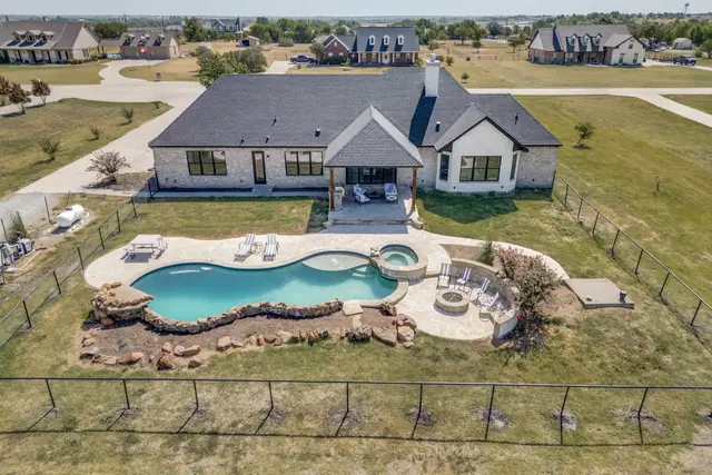 Aerial view showing the house, pool, patio, and the workshop/barn on the acreage