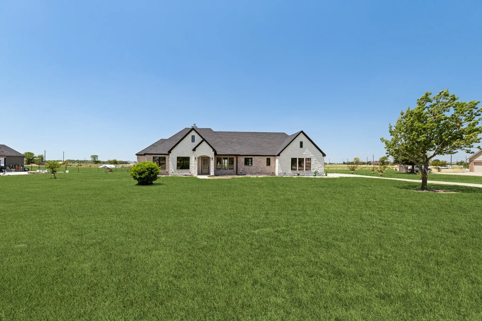 Front view of the single-story home seen across a wide green lawn