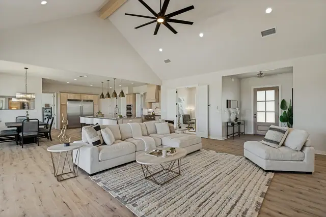 Wide view of the living area and dining space beneath a vaulted ceiling