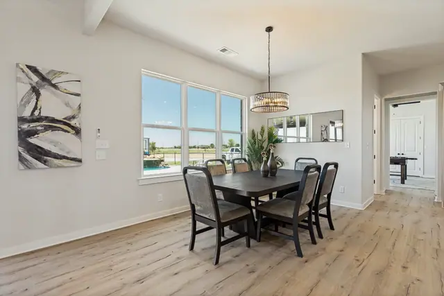 Dining room with a large table, pendant light, and windows