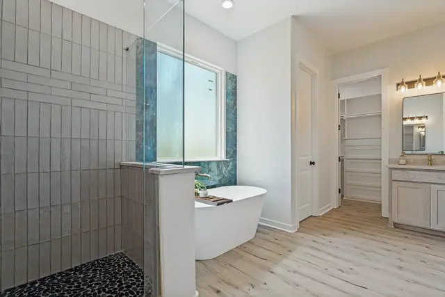 Bathroom with a freestanding soaking tub, glass shower, and vanity